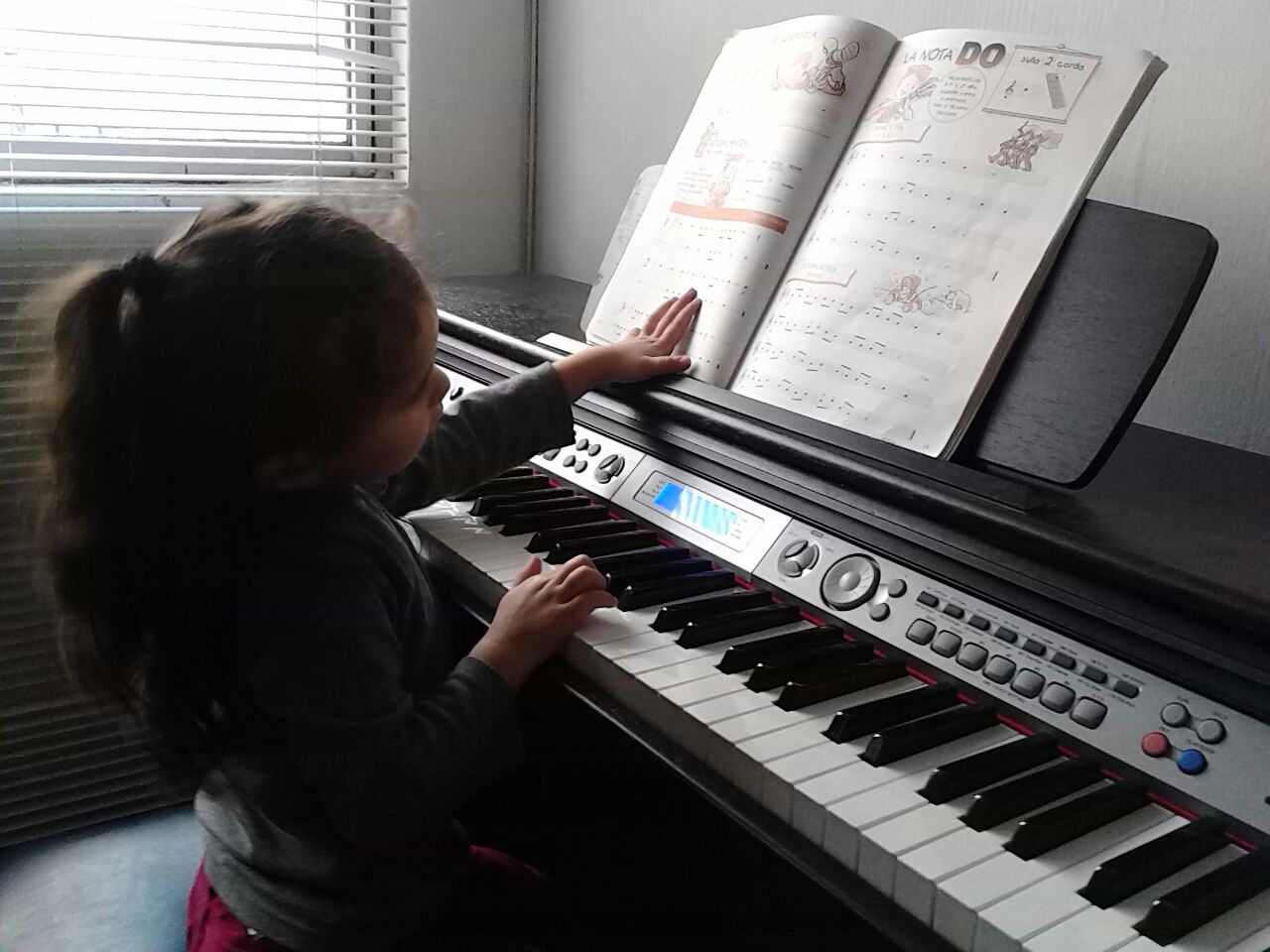 Niña aprendiendo a tocar piano